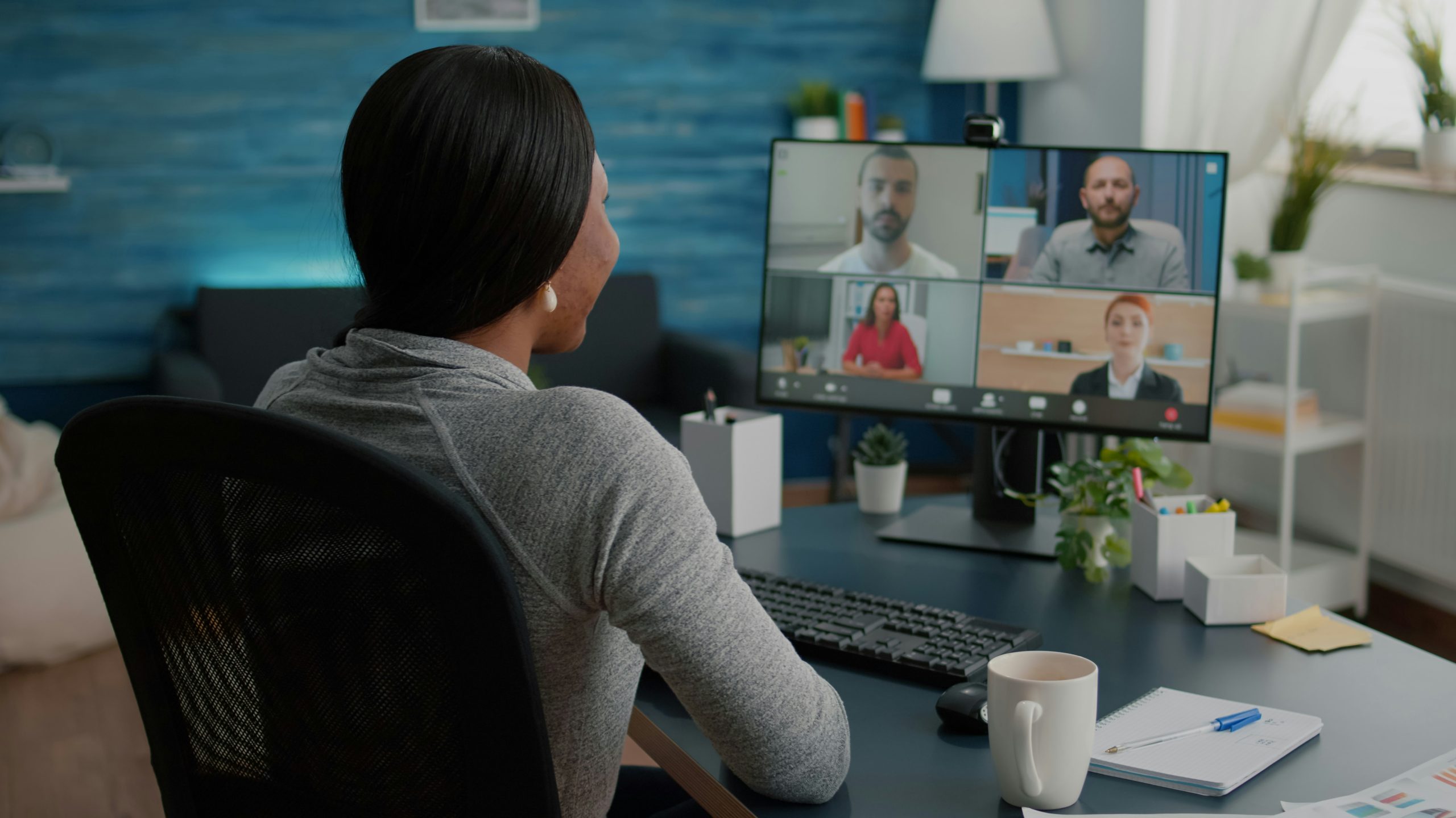 Resources 1 Person teaching online from a home office, speaking to students on a video call with a laptop and desk setup.